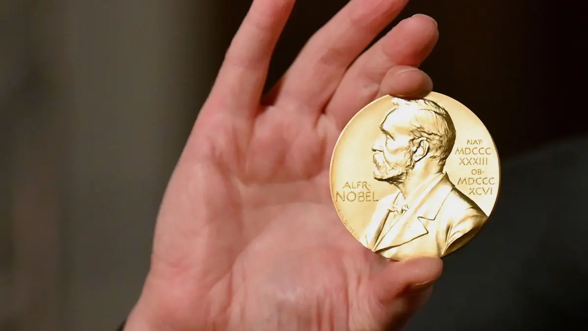 Nobelpreis: Eine Nobelmedaille wird während einer Zeremonie in New York hochgehalten. Nach der Vergabe des Medizin-Nobelpreises an die Grundlagenforschung zu Corona-Impfstoffen werden am Dienstag auch die Namen der Physik-Nobelpreisträger verkündet. (zu dpa: «Medizin-Nobelpreis an zwei Deutsche und einen US-Forscher»)