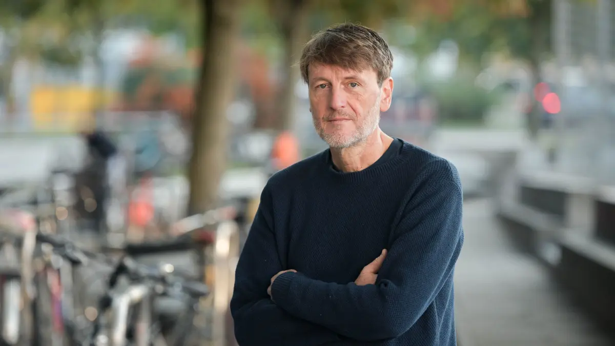 Tobias Dusche, RAF Ausstellung: Stuttgart, am Marienplatz.
In diesen Tagen ensteht aus einem leuchtend gelben Container ein HörKiosk auf dem Pariser Platz in Stuttgart, der das Publikum vom 15. Oktober bis 15. November 2026 dazu einlädt, sich mit der Architektur von Gerichtsgebäuden auseinanderzusetzen. Genauer gesagt: von Gerichtsgebäuden für Terrorprozesse. Der Ausgangspunkt für STRUKTUR STAMMHEIM, konzipiert von dem Stuttgarter Regisseur, Autor und Videogestalter Tobias Dusche in Kooperation mit der Akademie für gesprochenes Wort, ist das Prozessgebäude für das Oberlandesgericht Stuttgart in Stammheim. Die Genese dieses Baus von 2019 ist wiederum eng verwoben mit dem alten RAF-Gerichtssaal von 1975. Treffen mit Tobias Dusche.