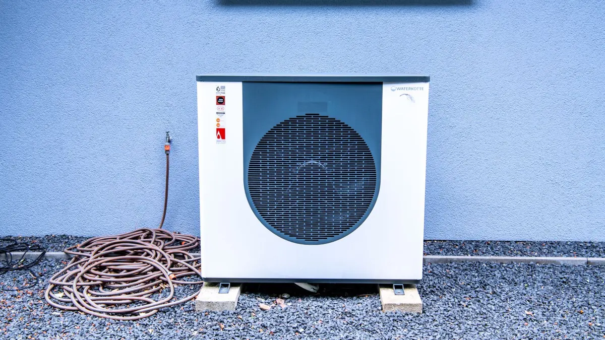 Eine Wärmepumpe vor einem Wohnhaus: ILLUSTRATION - Vor Beginn der Heizperiode sollte die Wärmepumpe gereinigt werden, da verschmutzte Lüftungsgitter ihre Funktion beeinträchtigen können. (zu dpa: «Warum die Wärmepumpe einen Herbstputz braucht») Foto: Laura Ludwig/dpa-mag - Honorarfrei nur für Bezieher des Dienstes dpa-Magazin +++ dpa-Magazin +++