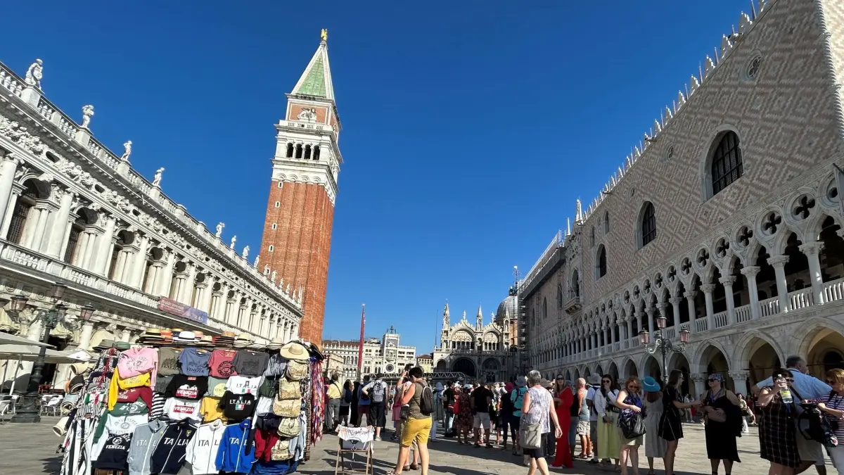 Blick auf den Markusplatz in Venedig: Touristen stehen auf dem Markusplatz mit Campanile (M) und Dogenpalast (r). (zu dpa: «Venedig kostet 2027 an noch mehr Tagen Eintritt»)