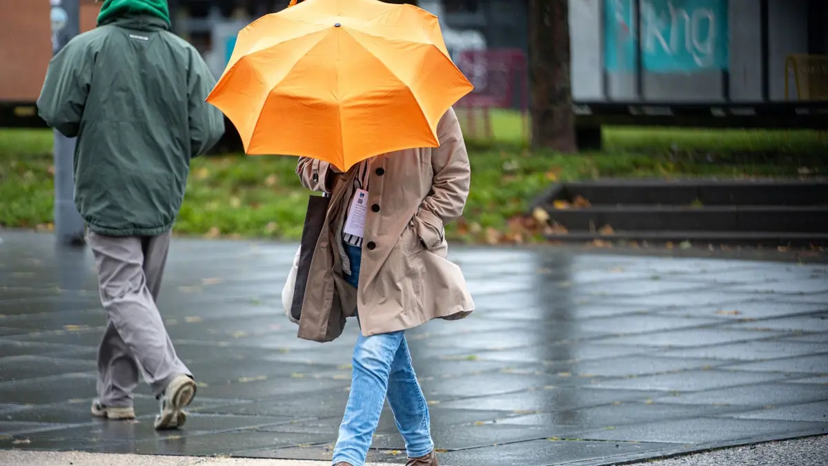 Wetter: ARCHIV - 24.09.2025, Saarland, Saarbrücken: Eine Frau läuft mit Regenschirm. (zu dpa: «Grau-trübes Wochenende - mehr Sonne zum Wochenstart») Foto: Laszlo Pinter/dpa +++ dpa-Bildfunk +++