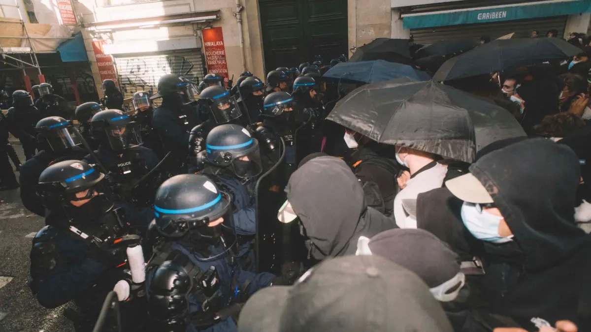 Protesttag in Frankreich: 17.10.2026, Frankreich, Paris: Bereitschaftspolizei und Demonstranten mit Regenschirmen stehen sich vor Beginn eines Marsches auf einer Straße in Paris gegenüber. Foto: Fabian Suspensivo/ZUMA Press Wire/dpa +++ dpa-Bildfunk +++