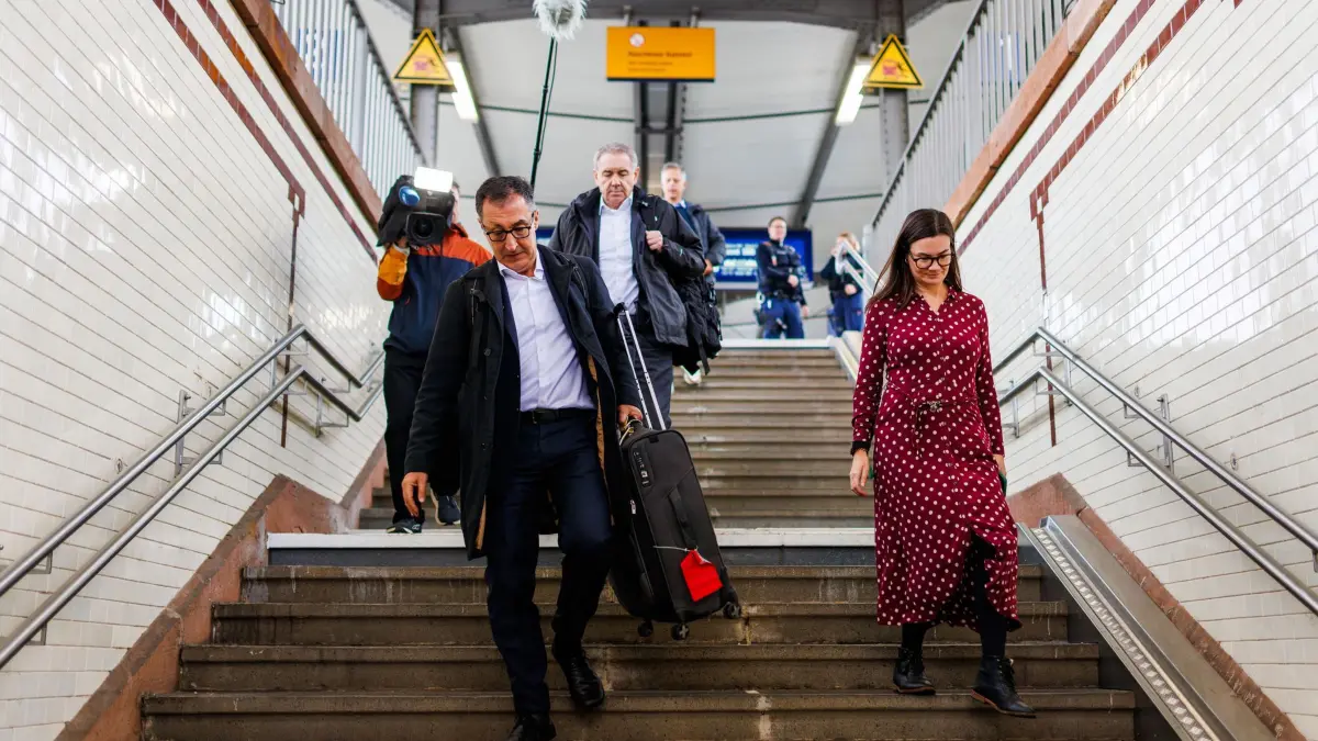 Auftakt Landesdelegiertenkonferenz Grüne Baden-Württemberg: 17.10.2026, Baden-Württemberg, Offenburg: Cem Özdemir (l, Bündnis 90/Die Grünen), Ministerpräsident von Baden-Württemberg, geht mit seinem Koffer über den Bahnhof. Der Landesverband der Grünen Baden-Württemberg trifft sich an diesem Wochenende unter dem Motto „Made in Baden-Württemberg“ in der Offenburger Oberrheinhalle zur Landesdelegiertenkonferenz. Foto: Philipp von Ditfurth/dpa +++ dpa-Bildfunk +++
