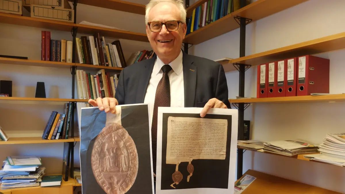 Dekan Eckart Schultz-Berg zeigt seinen historischen Fund zu den Namenspatronen der Cannstatter Stadtkirche: Eine Urkunde und Siegel mit Cosmas und Damian.