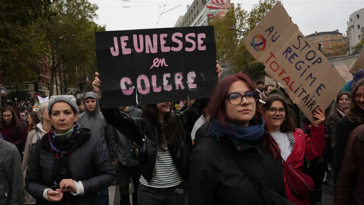 Proteste in Paris: 24.10.2026, Frankreich, Paris: Demonstranten mit einem Plakat mit der Aufschrift „Zornige Jugend“ marschieren bei einer Demonstration gegen steigende Lebenshaltungskosten in Paris. Foto: Thibault Camus/AP/dpa +++ dpa-Bildfunk +++