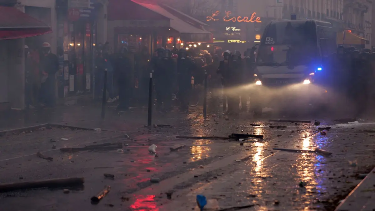 Proteste in Paris: 24.10.2026, Frankreich, Paris: Polizisten blockieren im Tränengasnebel eine Straße. Foto: Marcus Golejewski/dpa +++ dpa-Bildfunk +++