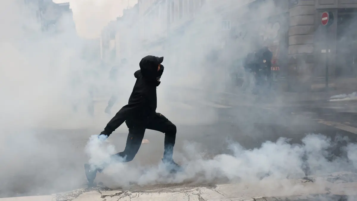 Proteste in Rennes: Ein Demonstrant wirft nach einer Demonstration gegen steigende Lebenshaltungskosten in Rennes, Frankreich, eine Tränengasgranate in Richtung der Polizei. (zu dpa: «Mindestens 1.000 Festnahmen nach Protesten in Frankreich»)