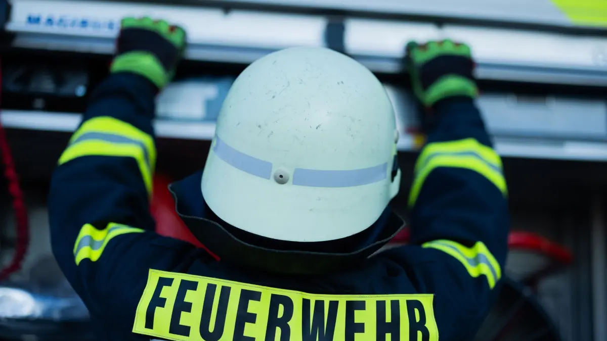 Feuerwehr - Symbolbild: Ein Feuerwehrmann holt Equipment aus einem Einsatzfahrzeug an der Feuerwache der Feuerwehr. (zu dpa: «Brand in Mehrfamilienhaus verursacht hohen Schaden»)