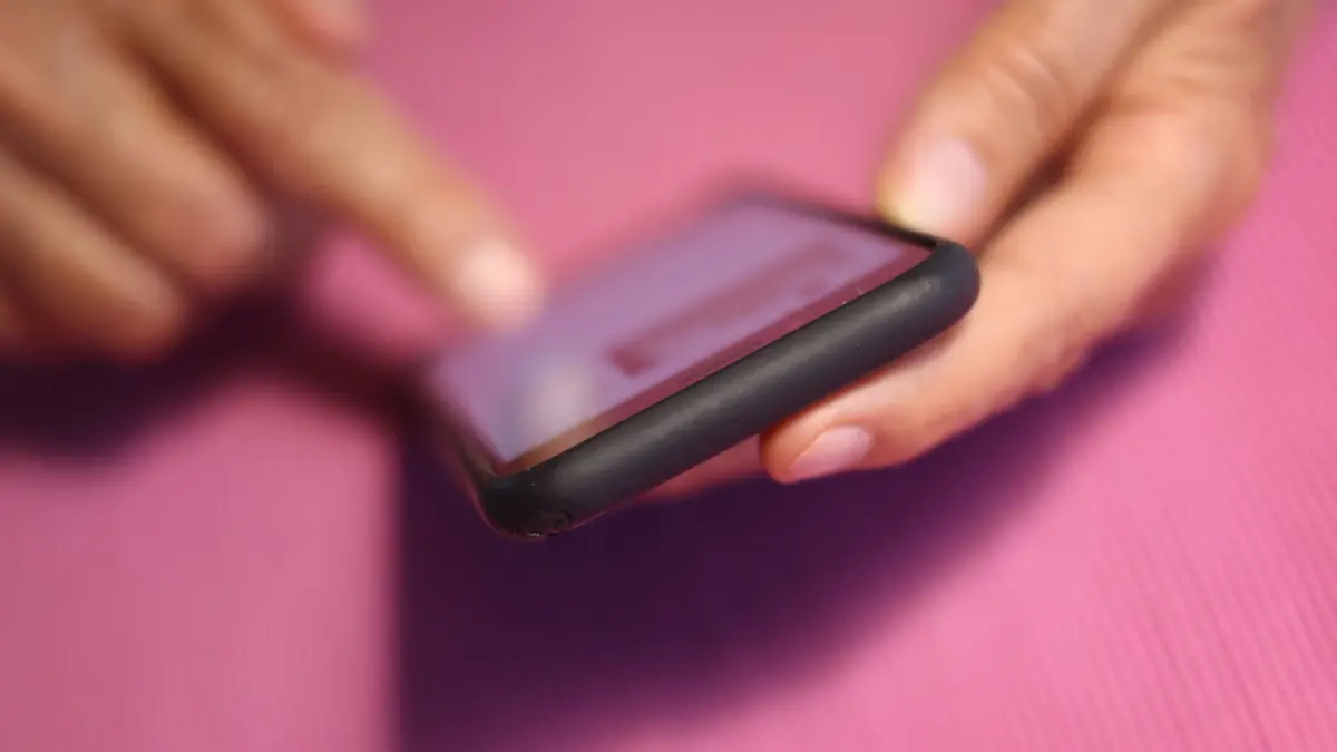 Eine Frau tippt auf einem iPhone: iPhone-Nutzer können in den iOS-Einstellungen jede Menge hilfreiche Schutzfunktionen für den Alltag finden. (zu dpa: «iPhone und iPad: 3 Tipps für mehr Sicherheit»)