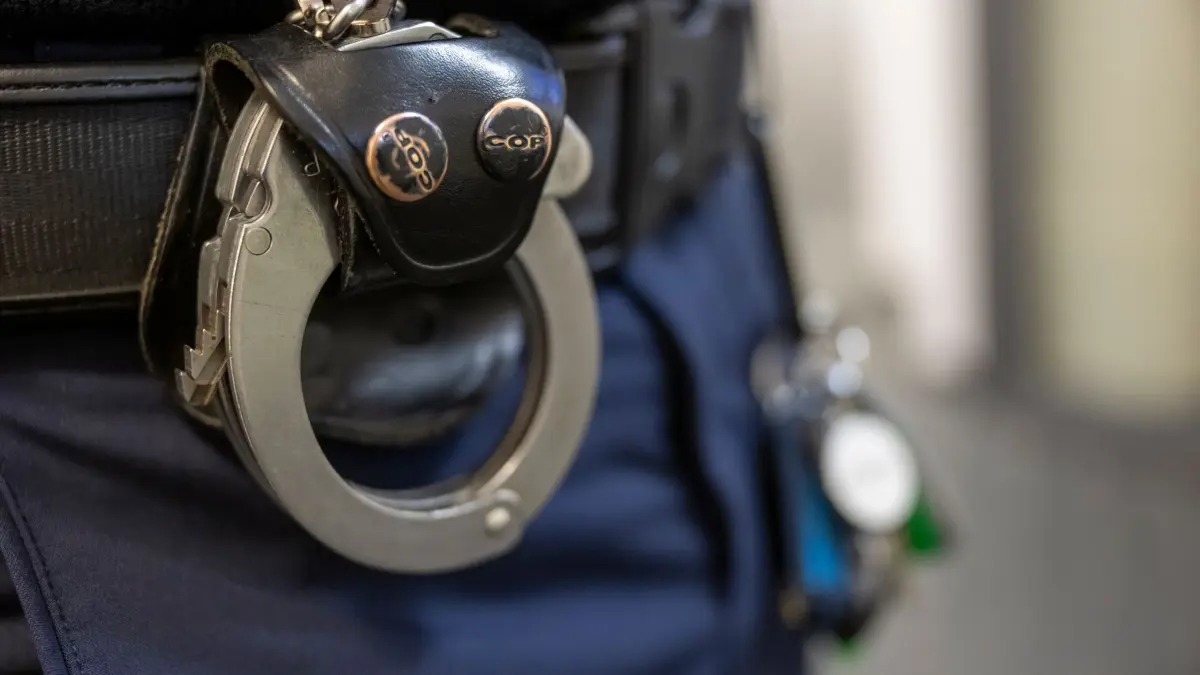 Polizei ermittelt wegen Agententätigkeit zu Sabotagezwecken: Eine Handschelle hängt am Gürtel eines Polizisten. (zu dpa: «Sabotageplan: Männer hatten vier Kanister bei sich»)